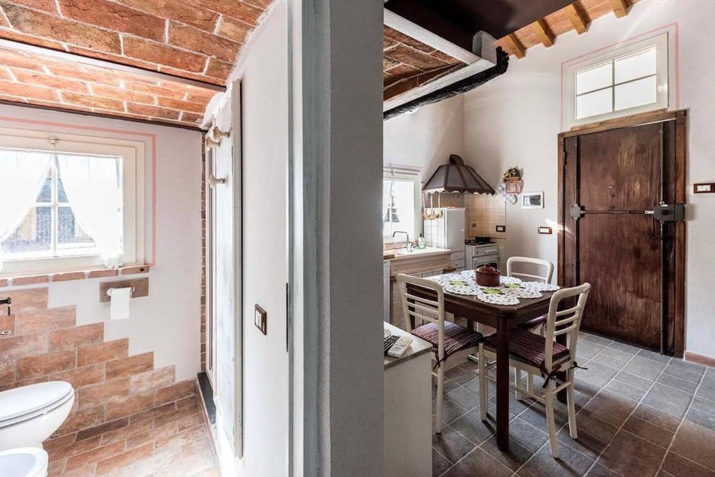 Il comprend une cuisine, une salle à manger avec une table et une salle de bains. dans l'établissement Villa Il Rustichino, country Villa with Pool, à Soianella