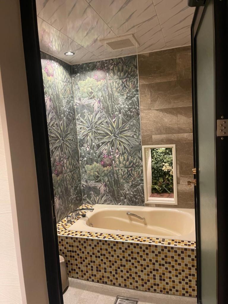 La salle de bains est pourvue d'une baignoire et de carrelage. dans l'établissement リンドス, à Okayama