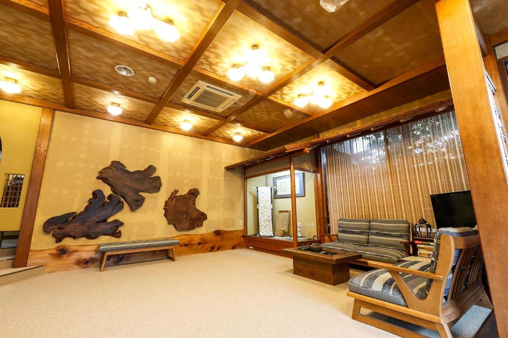 un salon avec un canapé et une télévision dans l'établissement Yanagiso, à Toyooka