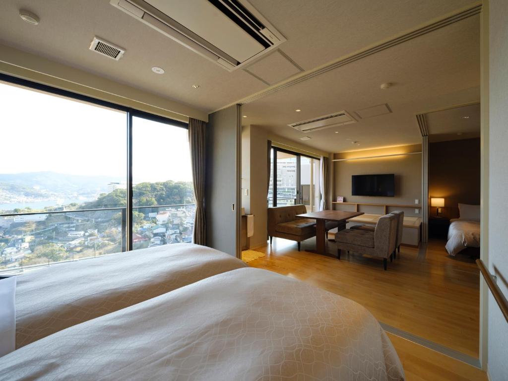 Cette chambre d'hôtel comprend un lit et un bureau avec vue. dans l'établissement Inasayama Kanko Hotel, à Nagasaki 37 autres photos