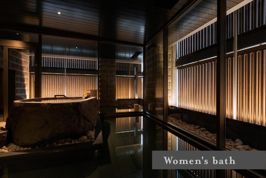 - une baignoire dans une chambre avec fenêtres dans l'établissement ONSEN RYOKAN Yuen Sapporo, à Sapporo