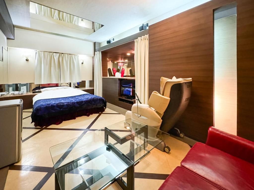 une chambre avec un lit et une table en verre dans l'établissement Fire Hotel Nw, à Saitama