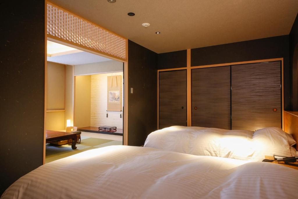 une chambre avec un grand lit blanc avec une grande fenêtre dans l'établissement Hotel Honnoji, à Kyoto