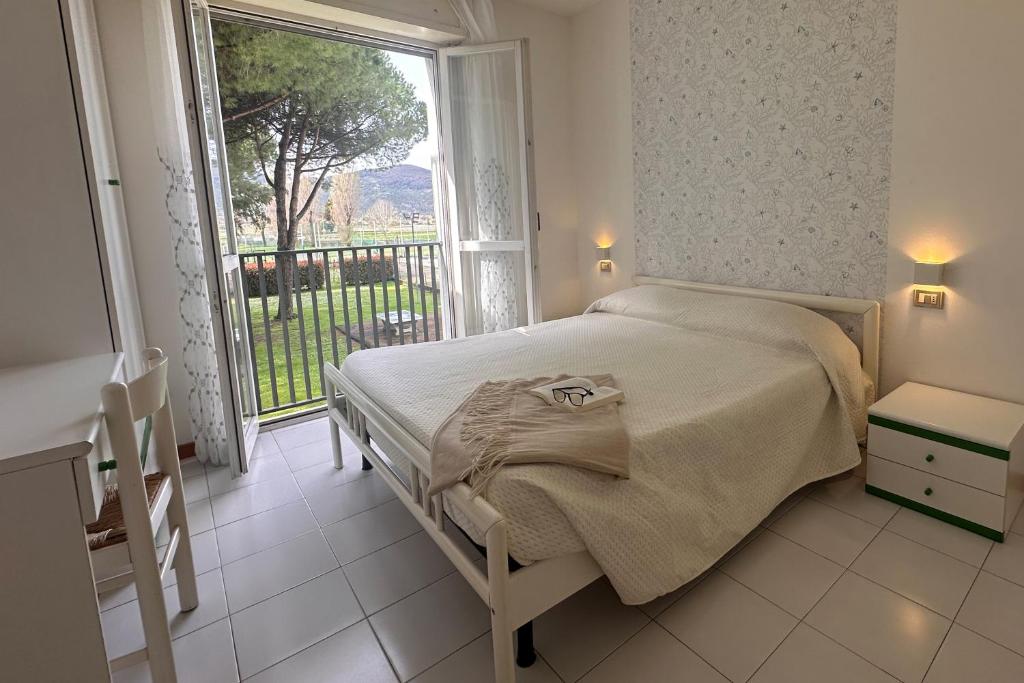 une chambre avec un lit et une grande fenêtre dans l'établissement Residenza Pierre & Vacances Luni Mare, à Luni