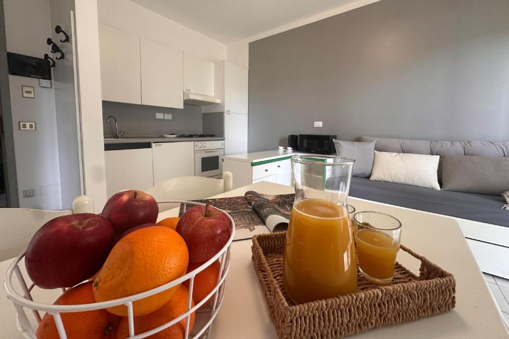 un bol de fruits et deux verres de jus d'orange sur une table dans l'établissement Residenza Pierre & Vacances Luni Mare, à Luni