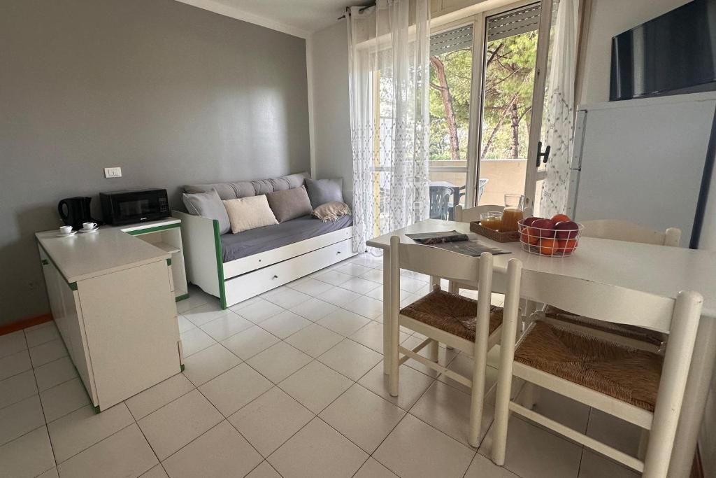 une cuisine et un salon avec une table et un canapé dans l'établissement Residenza Pierre & Vacances Luni Mare, à Luni