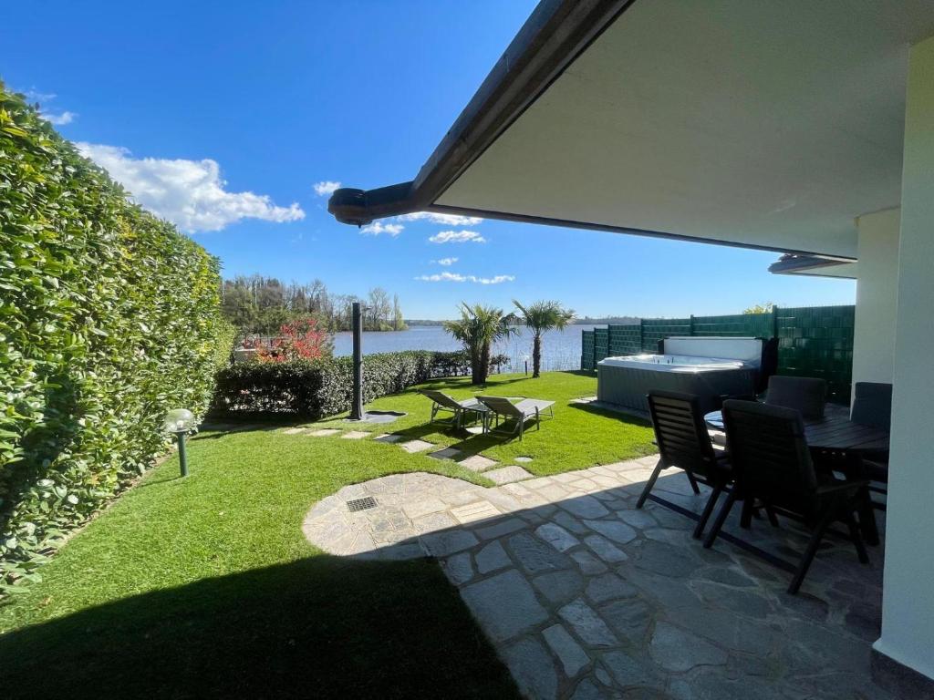 un patio avec une table et des chaises dans une cour dans l'établissement Lake Home Holiday Wellness Villa da sogno sul lago, à Pusiano