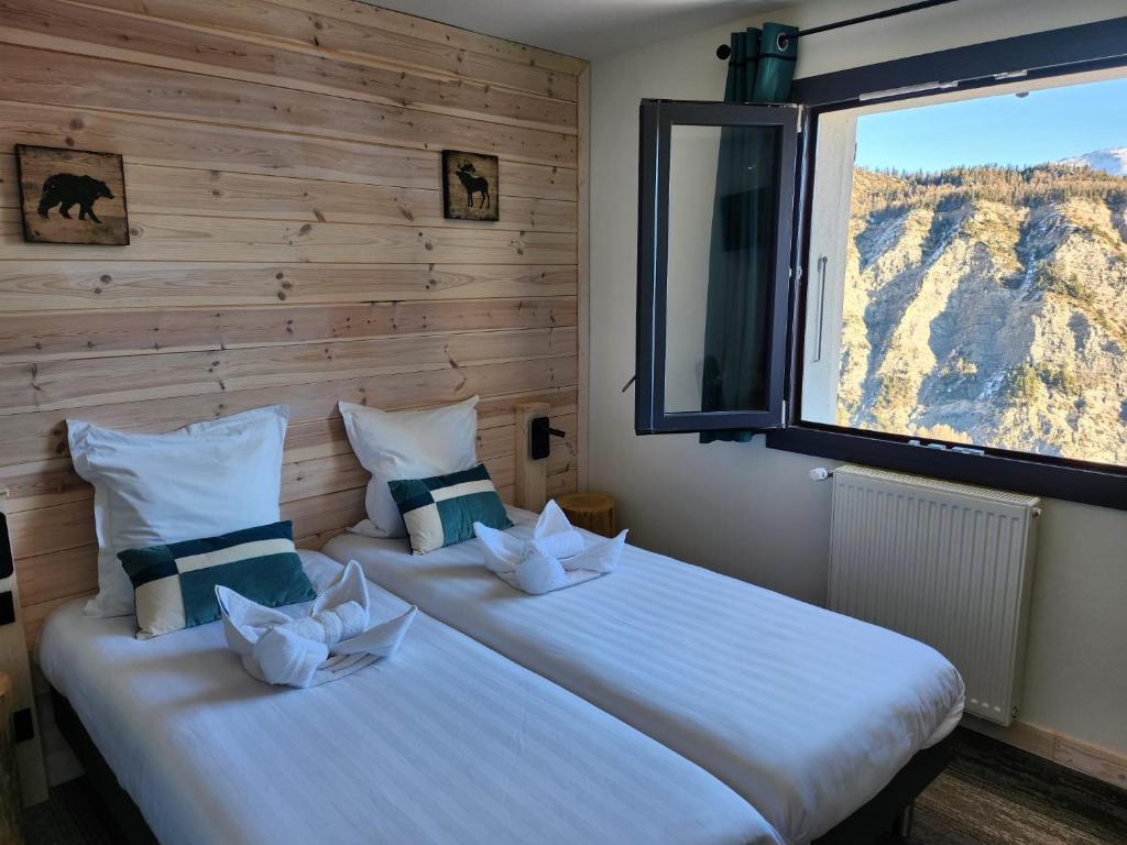 deux lits dans une chambre avec une fenêtre dans l'établissement Chalet Sainte Anne, à Condamine-Châtelard