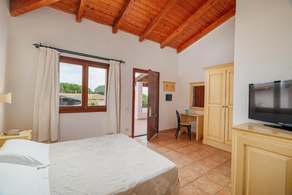 une chambre avec un lit et une télévision à écran plat dans l'établissement Club Esse Cala Gonone, à Cala Gonone