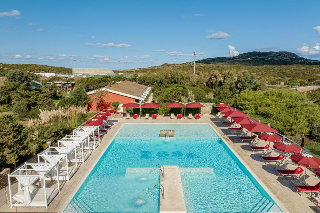 une vue aérienne d'une piscine avec des chaises et des parasols dans l'établissement Club Esse Sporting, à Stintino