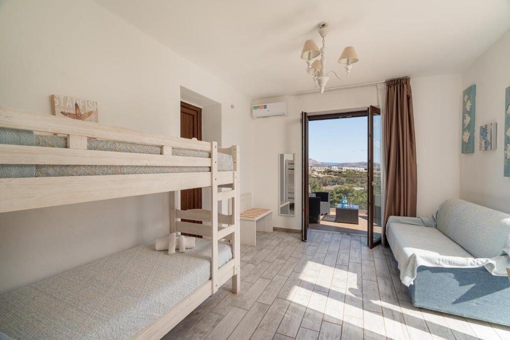 une chambre avec deux lits superposés et un canapé dans l'établissement Club Esse Sporting, à Stintino