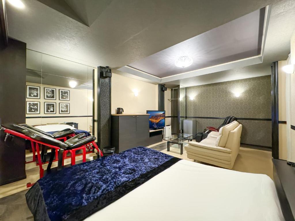 une chambre avec un lit et une chaise dans une pièce dans l'établissement Fire Hotel Nw, à Saitama 18 autres photos