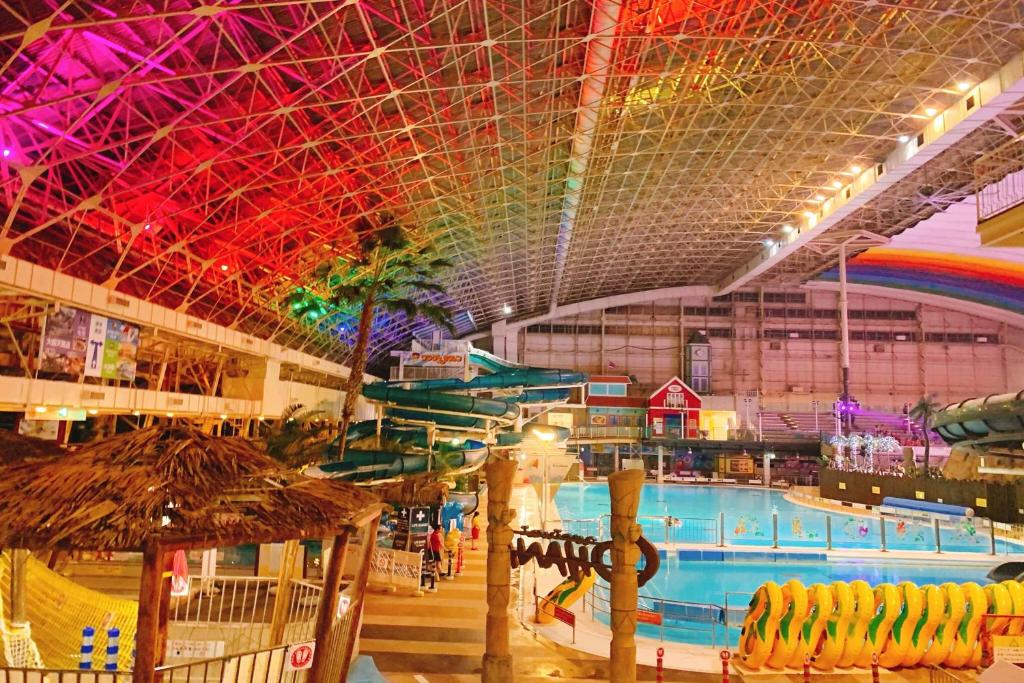 - une grande piscine intérieure dans un grand bâtiment dans l'établissement Spa Resort Hawaiians VIR Port, à Iwaki