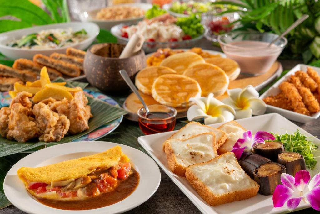 une table recouverte de assiettes de nourriture et d'amuse-gueules dans l'établissement Spa Resort Hawaiians Monolith Tower, à Iwaki 101 autres photos