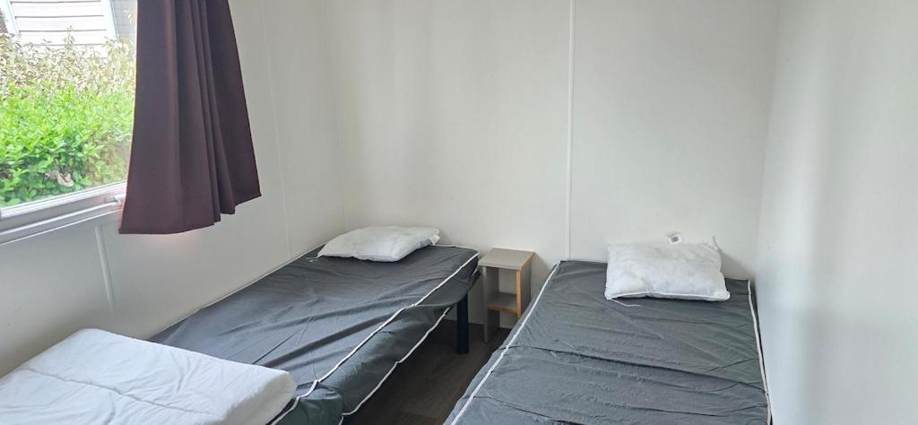 deux lits jumeaux dans une chambre avec fenêtre dans l'établissement MOBIL HOME CAMPING LES SABLES DU MIDI, à Sérignan 15 autres photos