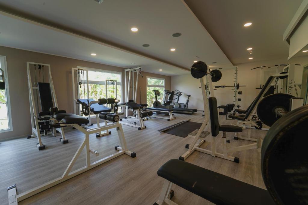 une salle de sport avec plusieurs tapis de course et machines dans une pièce dans l'établissement Hotel Villaggio Old River, à Capo Vaticano