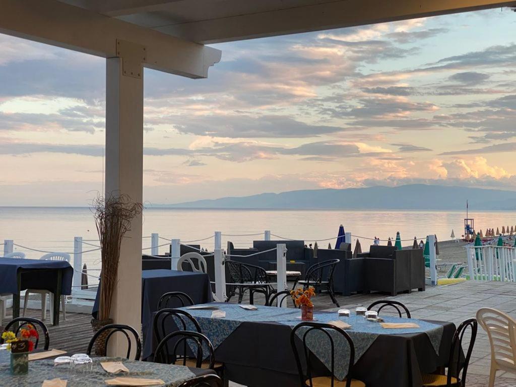 d'une terrasse avec des tables et des chaises offrant une vue sur l'eau. dans l'établissement Hotel Costa Jonica, à Sellia Marina 19 autres photos