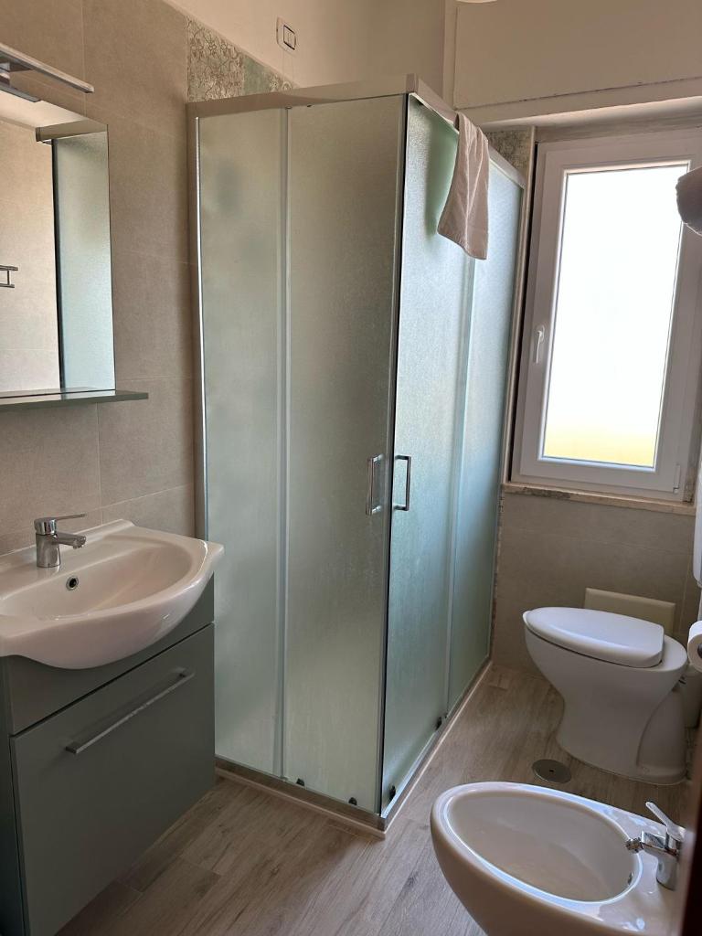 une salle de bain avec douche, lavabo et toilettes dans l'établissement Hotel Costa Jonica, à Sellia Marina
