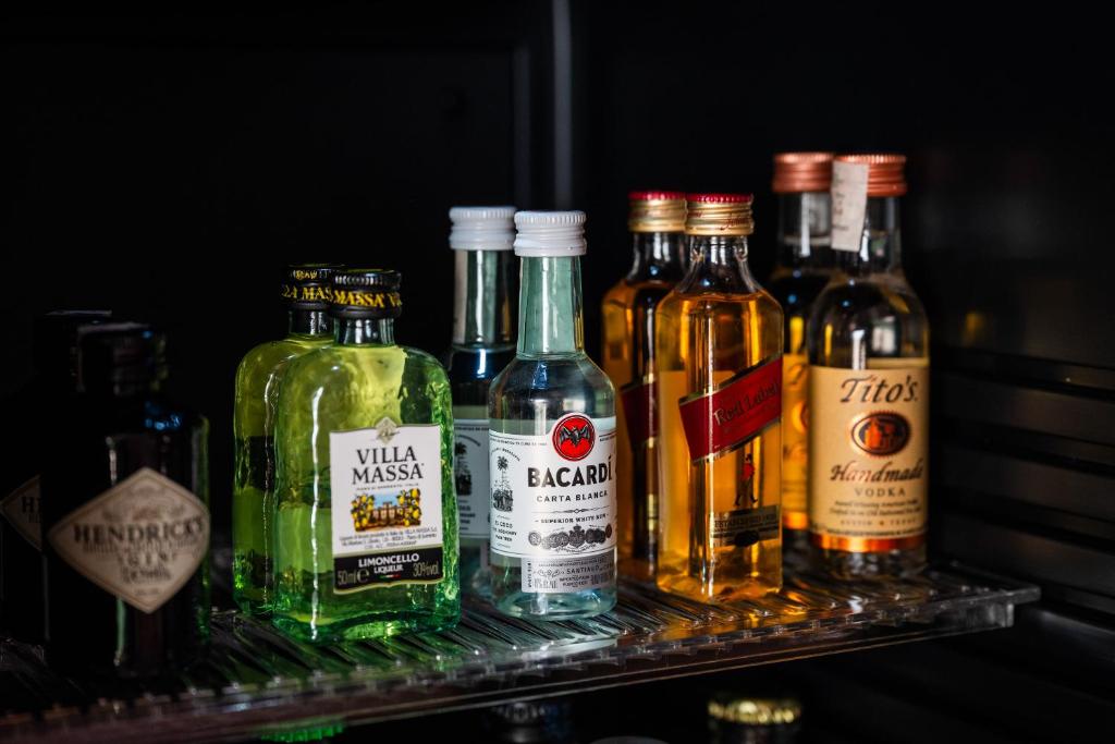 un groupe de bouteilles d'alcool assises sur une étagère dans l'établissement Antalia Boutique Hotel, à Positano