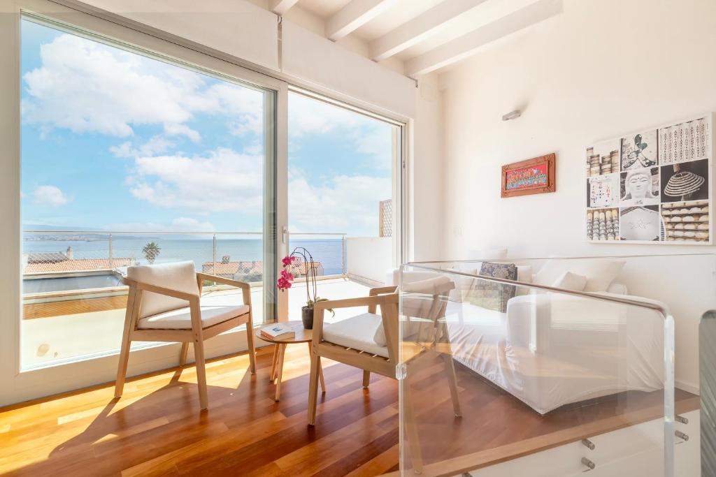 une salle à manger avec une table et des chaises et une grande fenêtre dans l'établissement Luxury Seafront Villa with Rooftop Pool & Stunning Sea Views, à Fertilia 82 autres photos