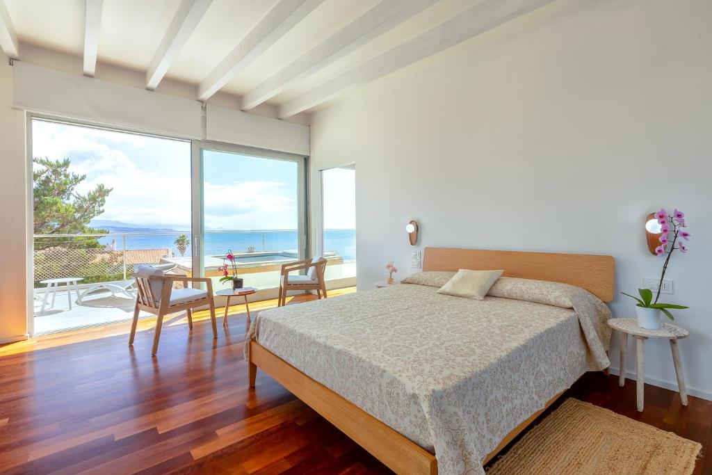 une chambre avec un lit et une vue sur l'océan dans l'établissement Luxury Seafront Villa with Rooftop Pool & Stunning Sea Views, à Fertilia