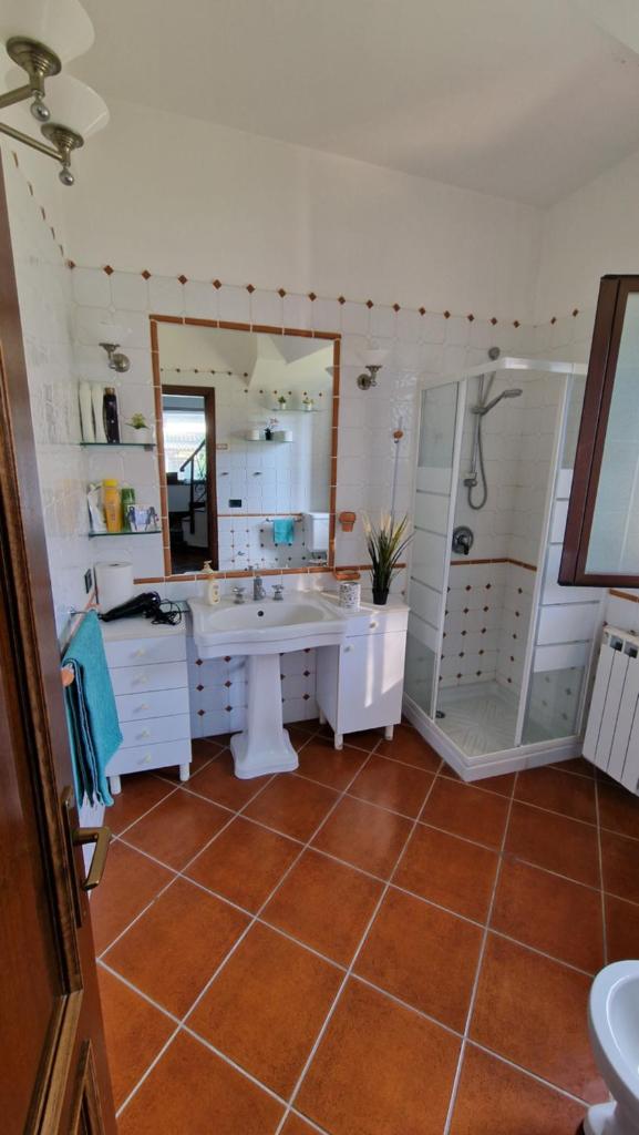 une salle de bain avec un lavabo, une douche et un miroir dans l'établissement Villa CARLOTTA, à Brucoli