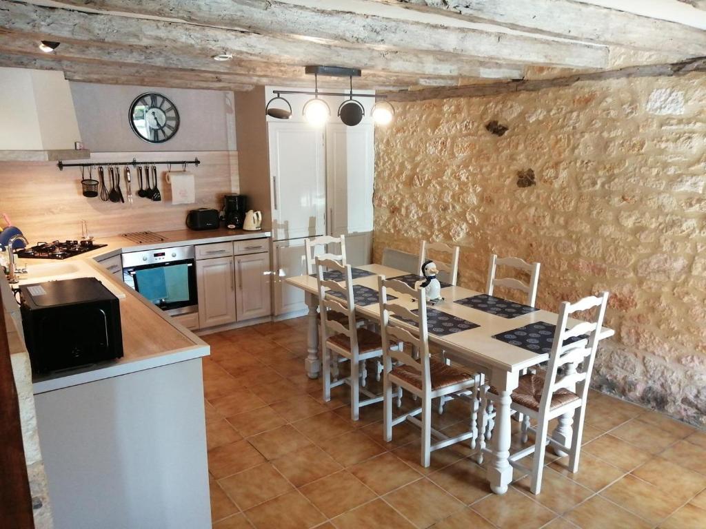 une cuisine avec une table et des chaises dans une pièce dans l'établissement Canterane, un coin de paradis à la campagne, à Salignac Eyvigues