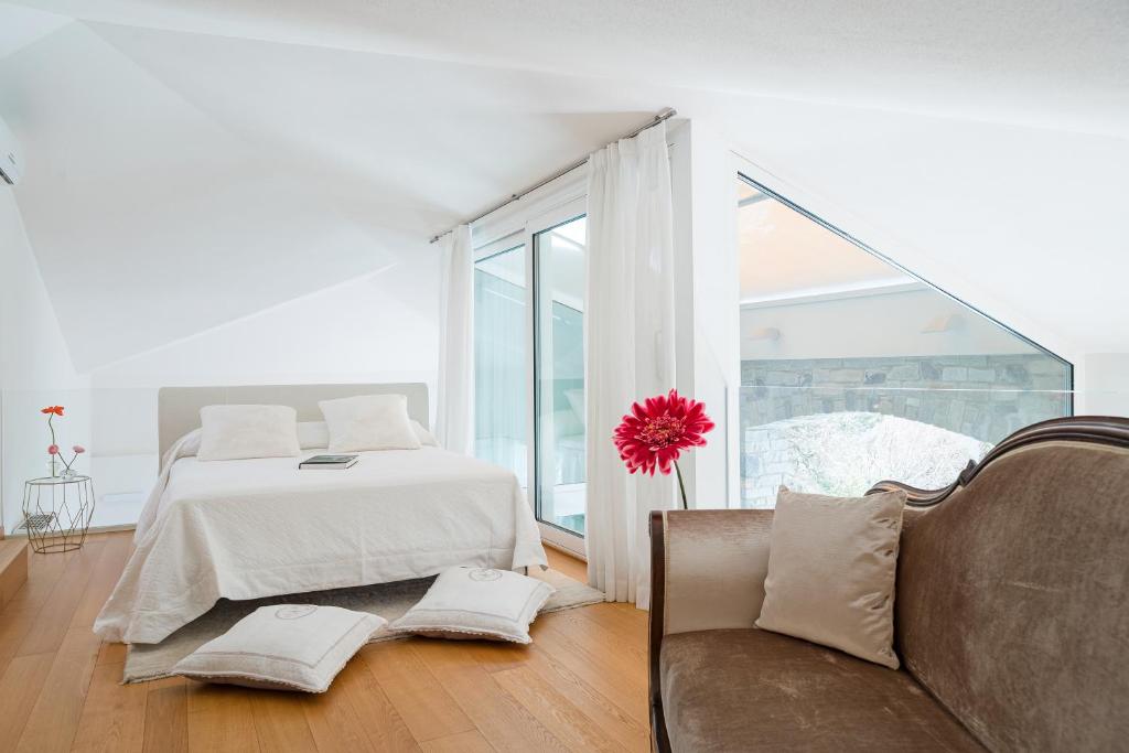 - une chambre blanche avec un lit et un canapé dans l'établissement Villa Meraviglia, à Griante Cadenabbia