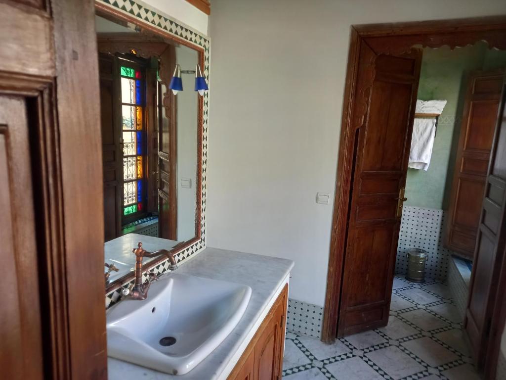 une salle de bain avec un lavabo et un miroir dans l'établissement Riad Jaouhara, à Fès