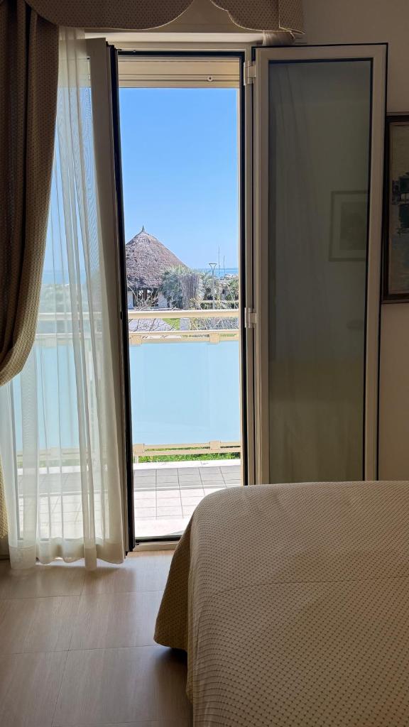 - une chambre avec une grande porte en verre offrant une vue dans l'établissement Hotel Ariella, à Milano Marittima
