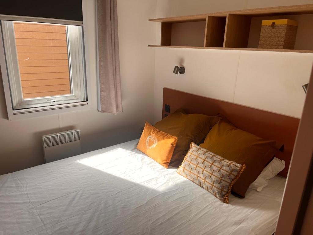 - une chambre avec un lit avec deux oreillers et une fenêtre dans l'établissement Bungalow Mobil Home Carry-le-rouet, à Carry-le-Rouet 9 autres photos