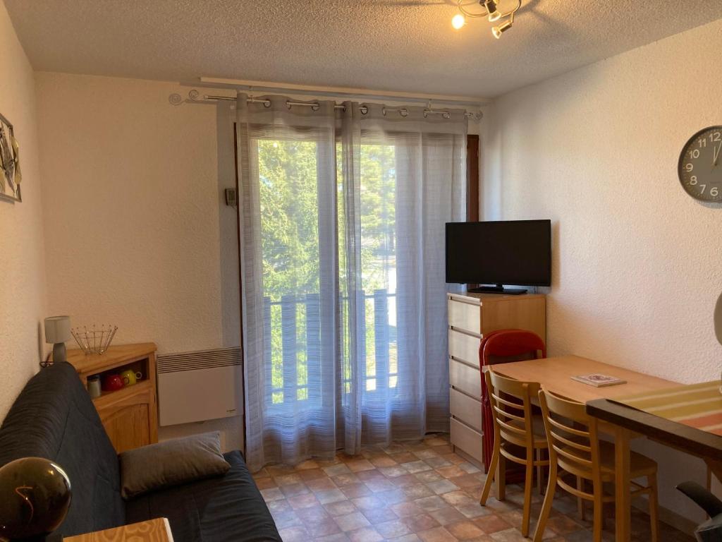 un salon avec un canapé, une table et une télévision dans l'établissement STUDIO 4 COUCHAGES A St JEAN-MONTCLAR ÉTÉ/HIVER, à Montclar