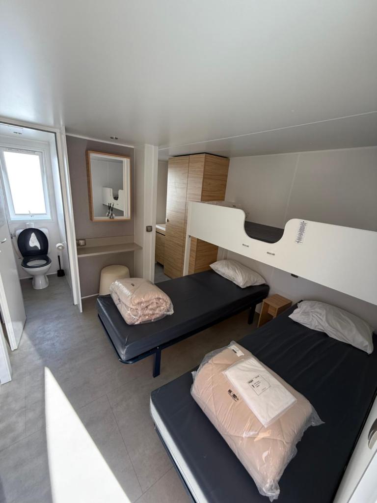 - une chambre avec 2 lits superposés et un miroir dans l'établissement Camping 5 étoiles domaine de la Yole, à Vendres