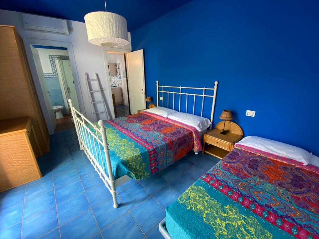 une chambre avec deux lits et un mur bleu dans l'établissement Residence Ambra, à Lido di Jesolo