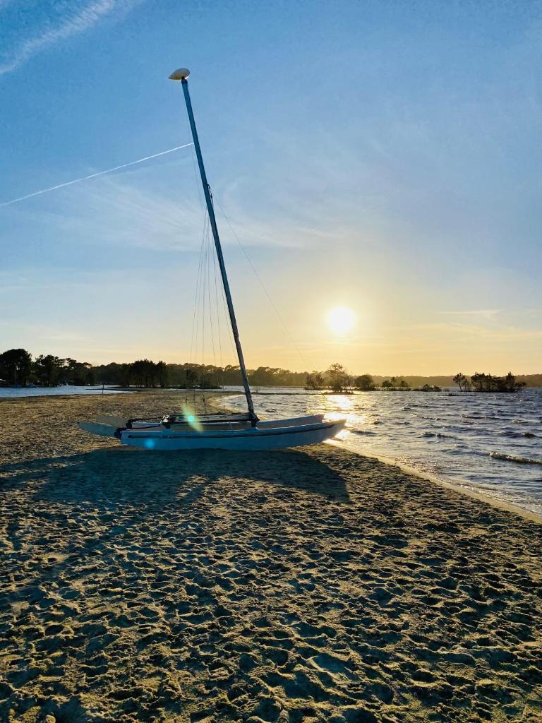 - un voilier assis sur le sable sur la plage dans l'établissement Mobilhome Harmonie, à Biscarrosse