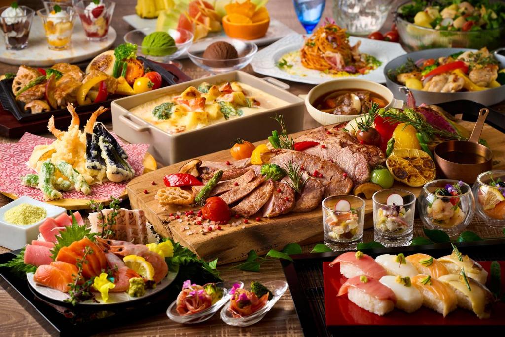 une table garnie de nombreux types d'aliments différents dans l'établissement Ooedo Onsen Monogatari Premium Ito Hotel New Okabe, à Itō