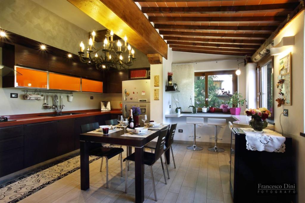 une cuisine avec une table et des chaises dans une cuisine dans l'établissement Chianti Luxury villa con piscina e idromassaggio, à San Donnino