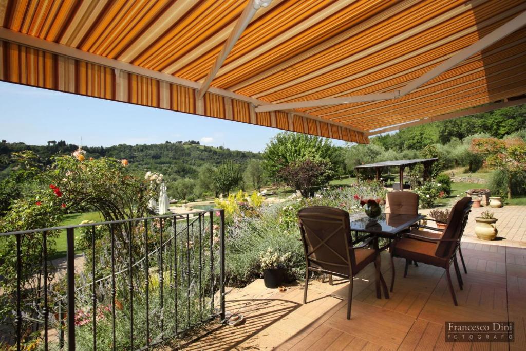 un patio avec une table et des chaises sur une terrasse dans l'établissement Chianti Luxury villa con piscina e idromassaggio, à San Donnino
