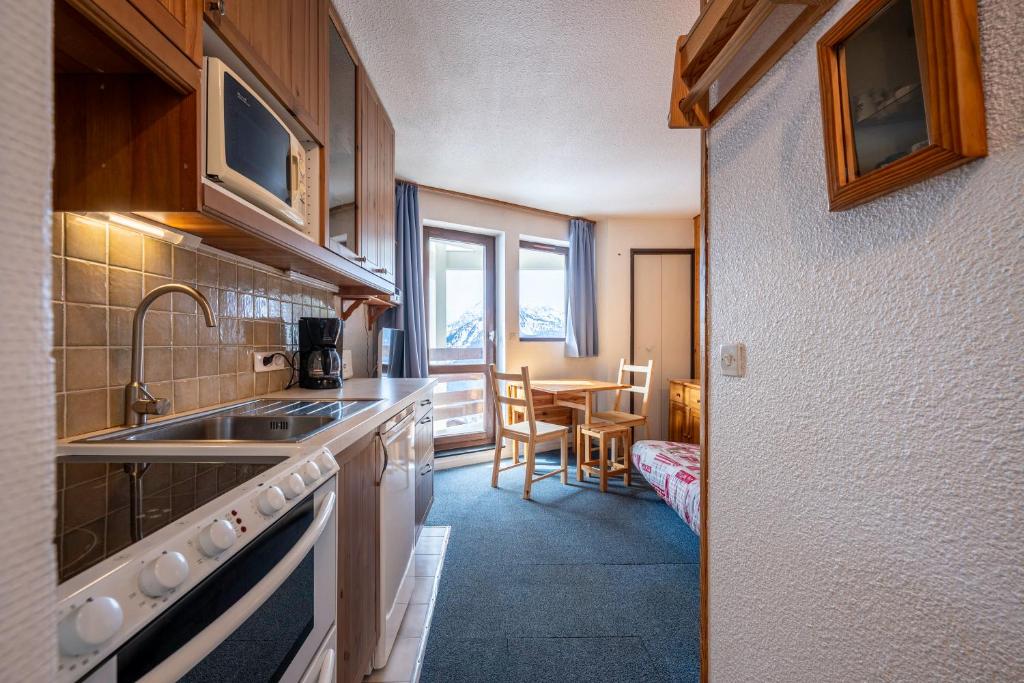 - une cuisine avec un évier et une table dans l'établissement Les Bouquetins A, à La Rosière