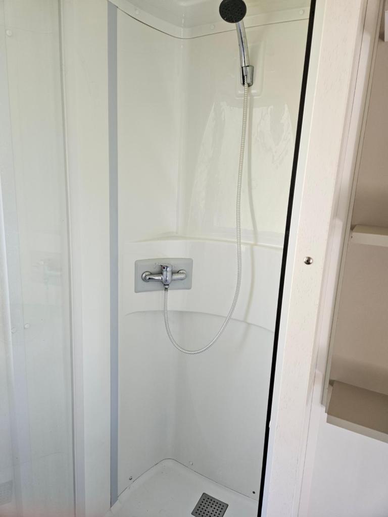 La salle de bains est pourvue d'une douche et de toilettes. dans l'établissement Camping familial les Chalets d'Uza, à Uza