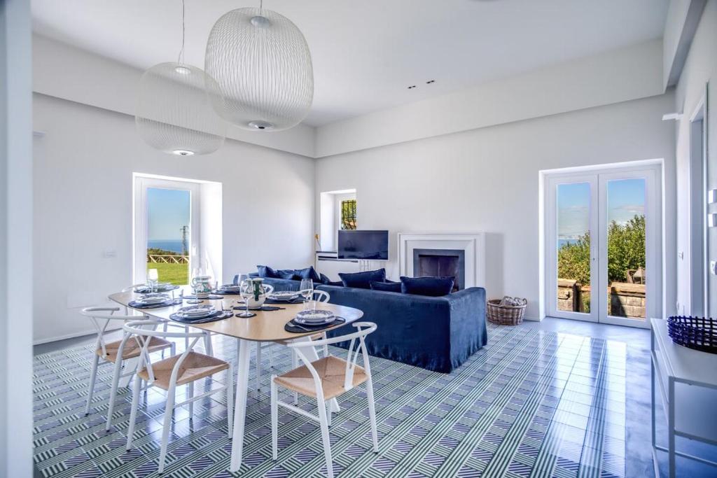 un salon avec une table et un canapé bleu dans l'établissement Casa del Capitano with Heated Pool, Views and Concierge by Feeling Italy, à Massa Lubrense