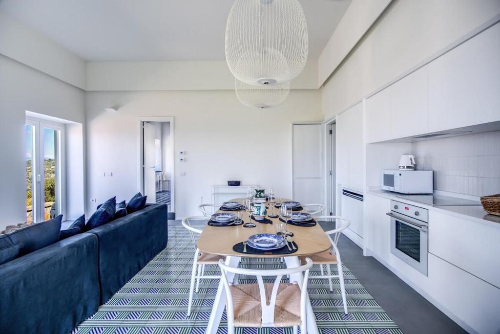 une cuisine et un salon avec une table et un canapé dans l'établissement Casa del Capitano with Heated Pool, Views and Concierge by Feeling Italy, à Massa Lubrense