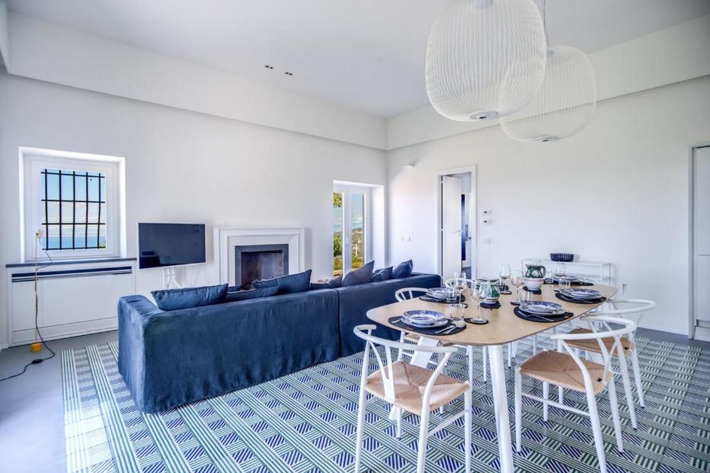un salon avec une table et un canapé bleu dans l'établissement Casa del Capitano with Heated Pool, Views and Concierge by Feeling Italy, à Massa Lubrense