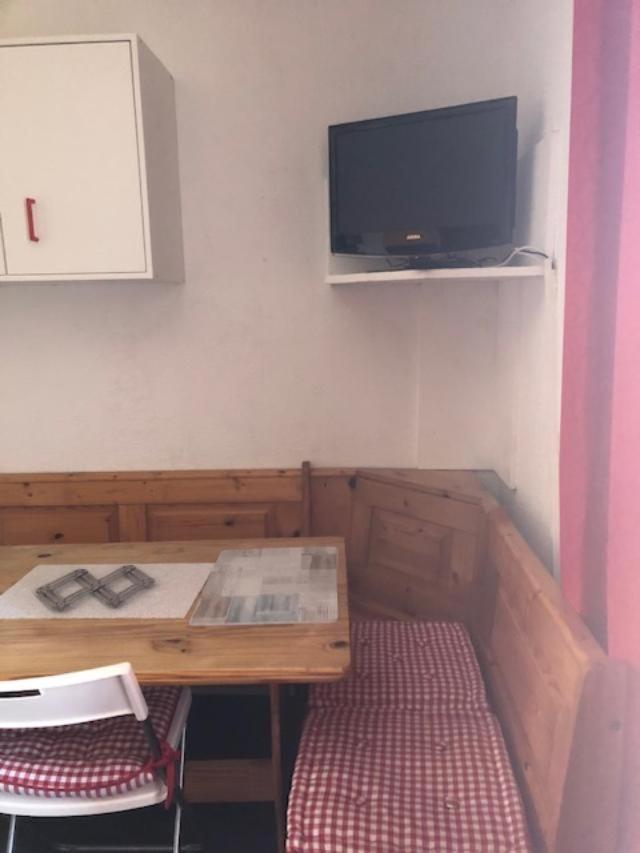 Cette chambre dispose d'une table en bois et d'une télévision murale. dans l'établissement joli studio montagne au pied des pistes, à Allos