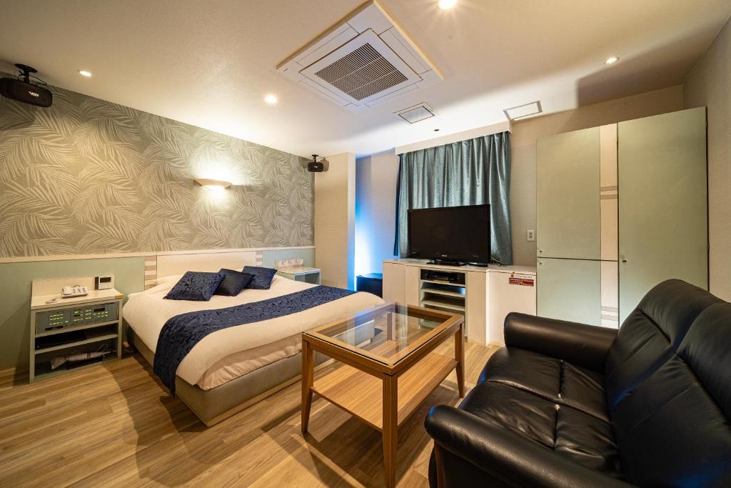 une chambre d'hôtel avec un lit et un canapé dans l'établissement ルトゥール姫路 Retur HIMEJI 男塾ホテルグループ, à Himeji