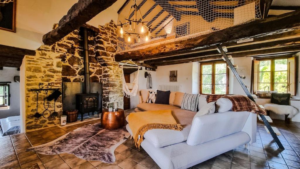 - un salon avec un canapé et une cheminée en pierre dans l'établissement Casa Isabella - Villa mit Pool und Sauna, à Pierle