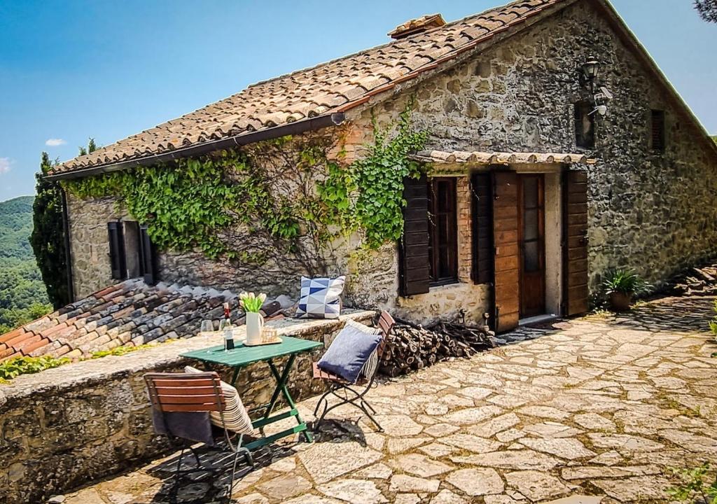 une maison en pierre avec une table et des chaises devant elle dans l'établissement Casa Isabella - Villa mit Pool und Sauna, à Pierle
