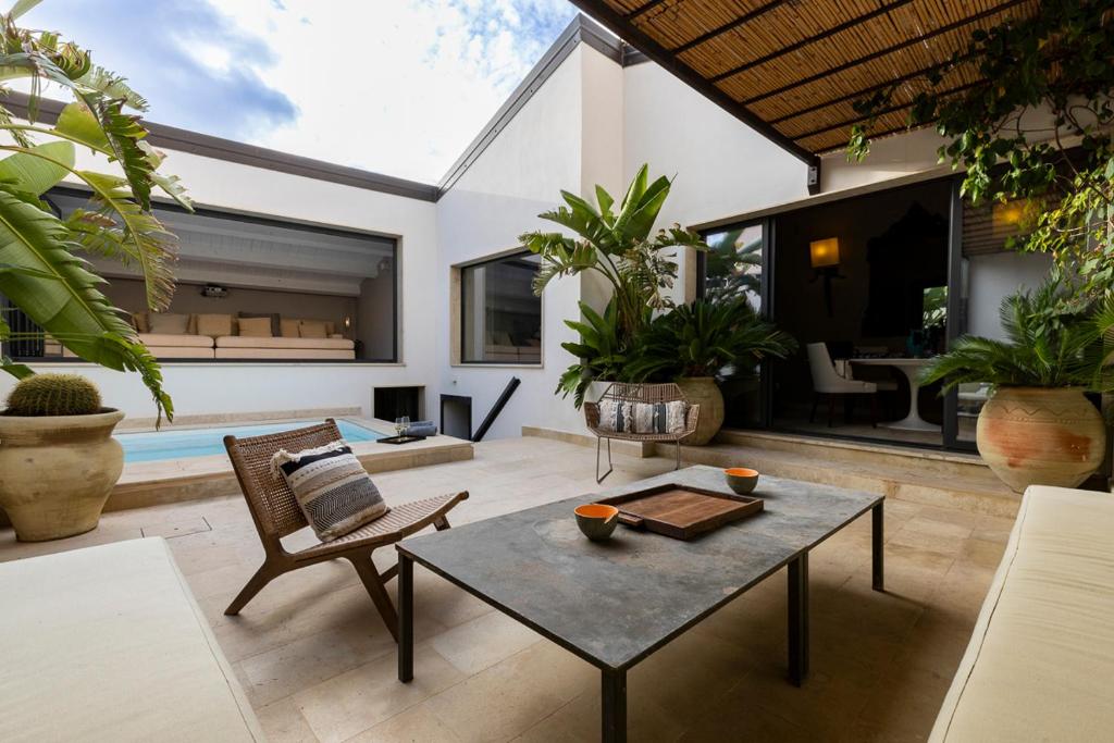 un salon avec une table et des chaises et une piscine dans l'établissement Secret Riad con piscina privata, à Noto