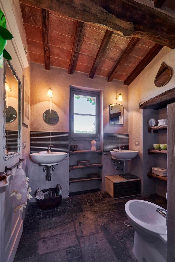 une salle de bain avec deux lavabos et une fenêtre dans l'établissement Villa Bacciana, à Montone