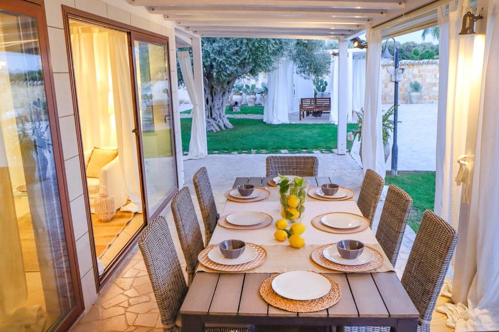 - une table en bois avec des assiettes et des fruits dans l'établissement Villa Erika piscina privata, à Ispica